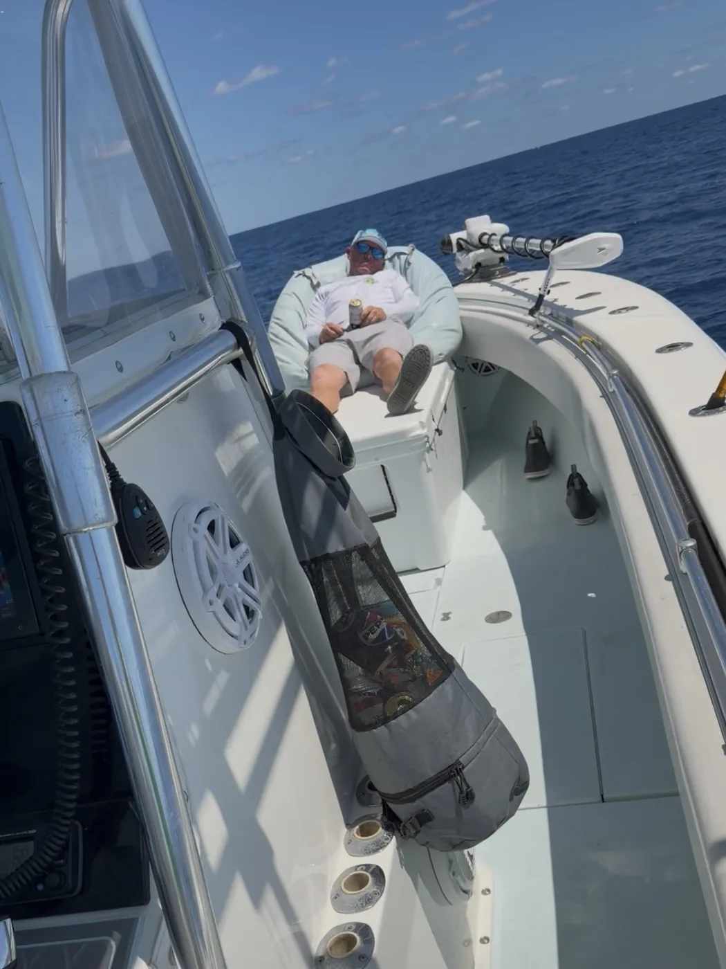 A mesh boat trash bag hanging off the grab rail, keeping the cockpit floor clear