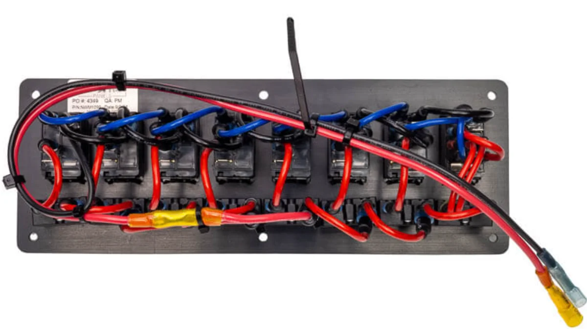 The back of the same panel: breakers, jumpers, and cable-tied wiring runs to the bus