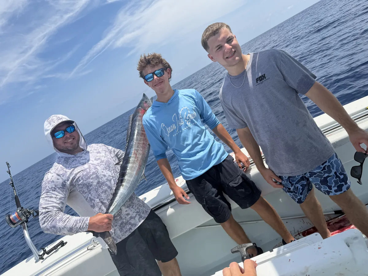 The wahoo from the surface bite, boatside with the crew before it hit the cooler